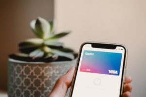 smartfon z kartą revolut i kwiatkiem w tle